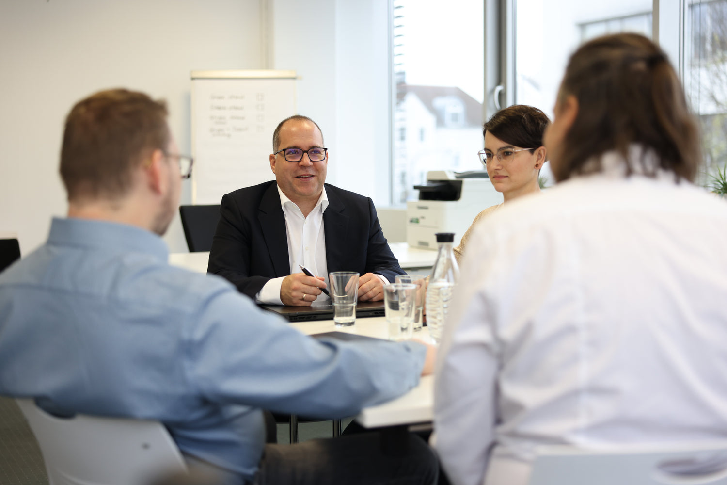 Professionelle Inhouse-Beratung für Krisenmanagement: Vier Personen im Workshop-Gespräch am Konferenztisch.